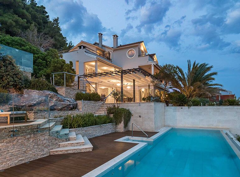 Villa at night with pool and garden